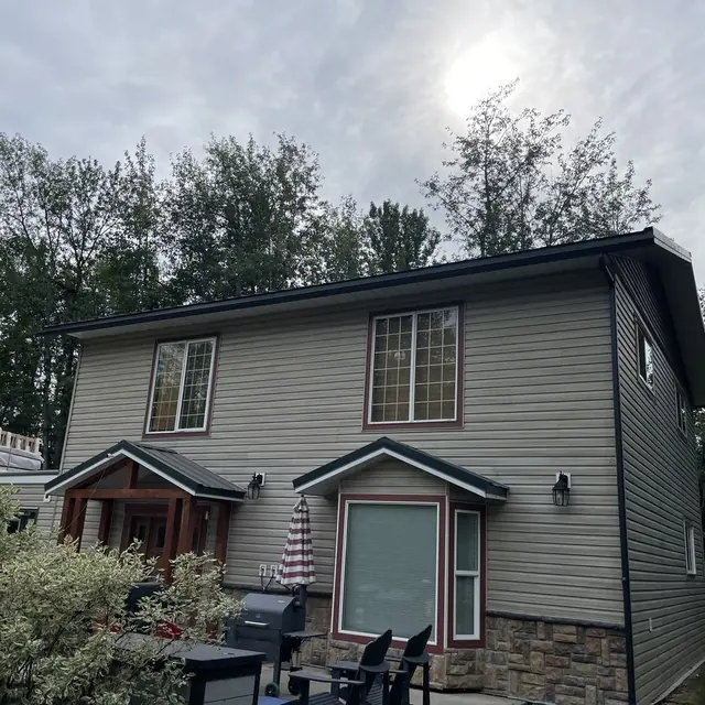 Professional gutter installation showing clean fascia and downspout placement